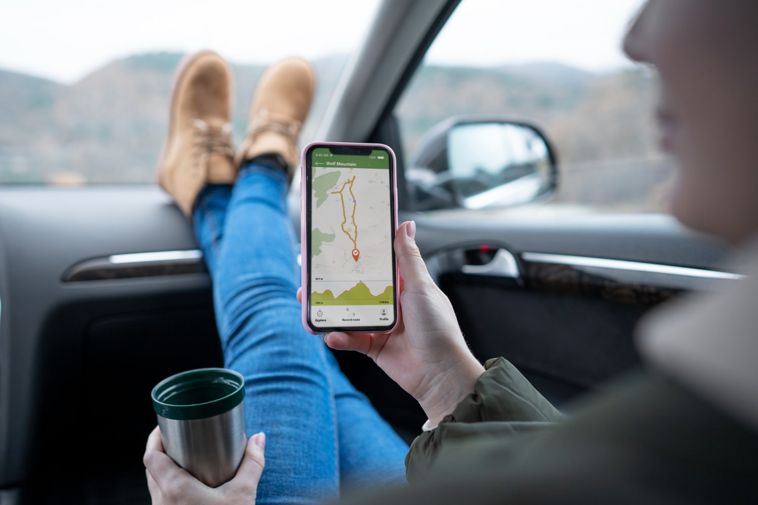 person using GPS in smartphone and a coffee cup in other hand