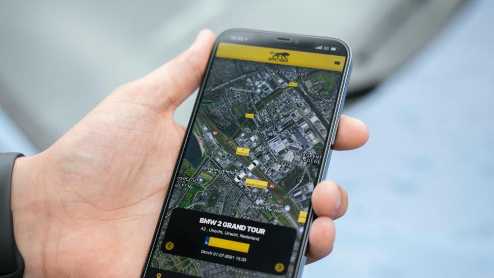  A hand holds a smartphone displaying a detailed map for the BMW 2 Grand Tour in Utrecht, Netherlands, with location markers visible.